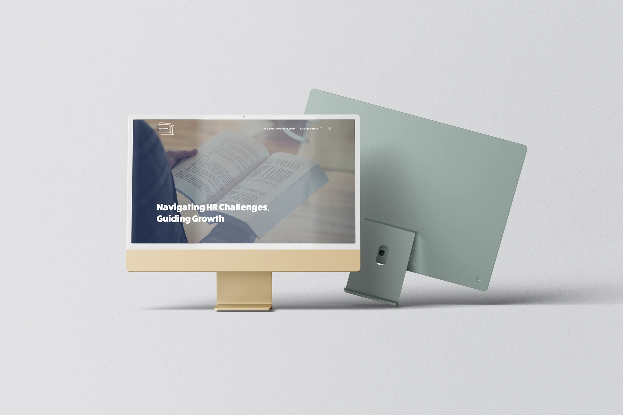 Computer monitor displaying 'Navigating HR Challenges, Guiding Growth' with a tablet on a light grey.