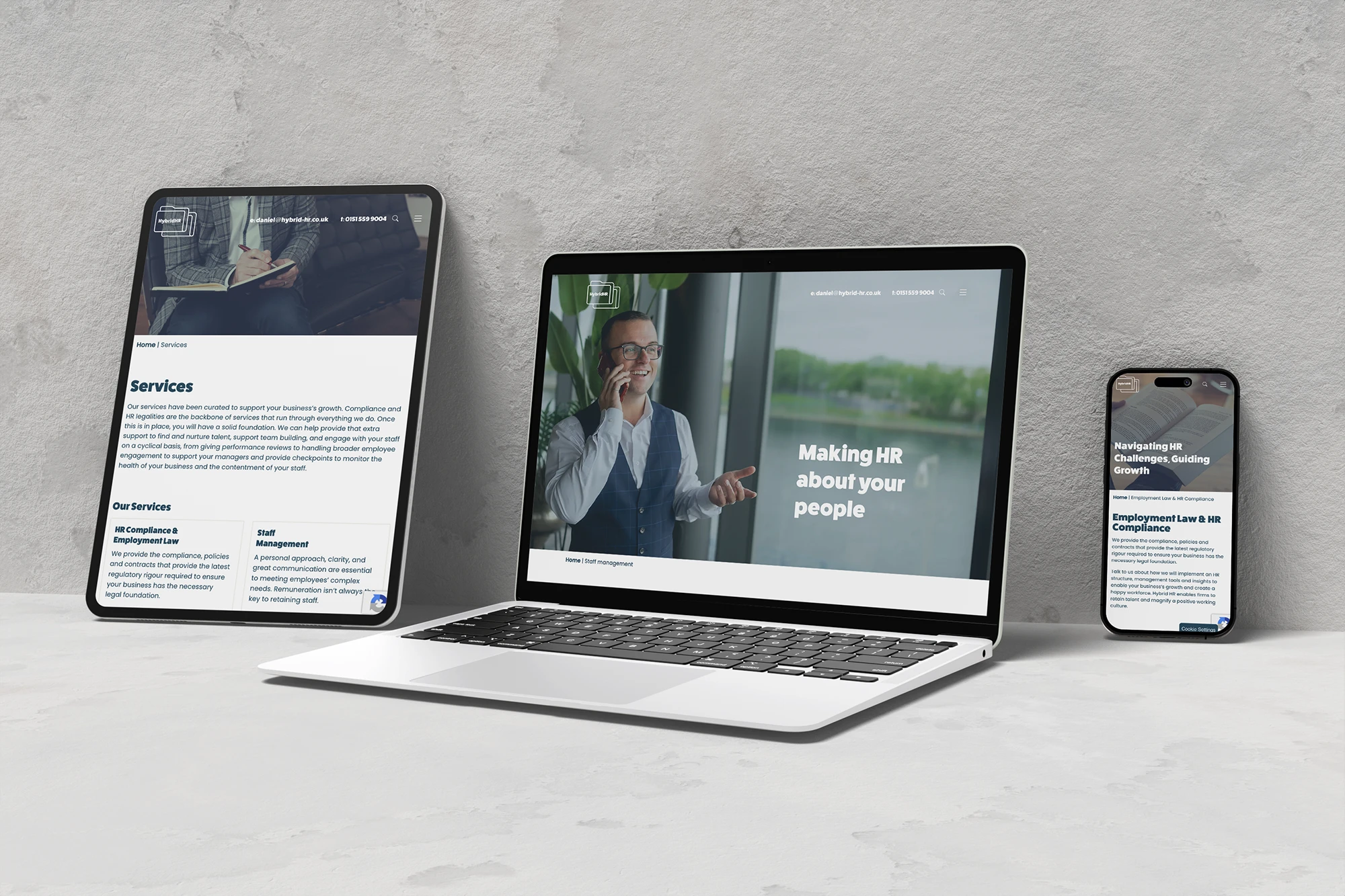 Digital devices displaying HR and business services on a concrete background.