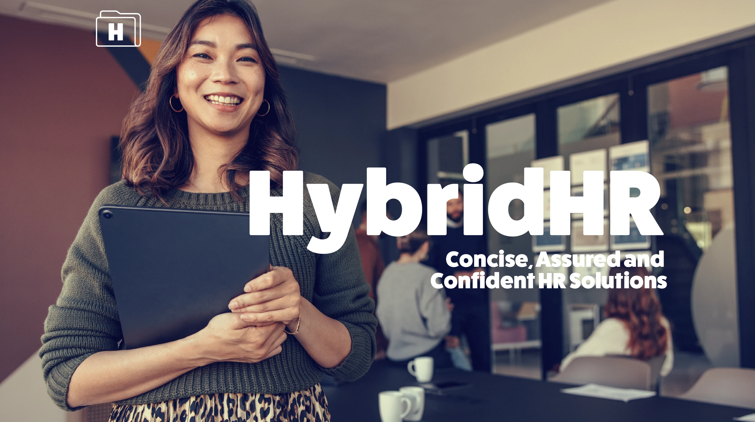 Confident woman holding a tablet at a modern office with Hybrid HR branding.