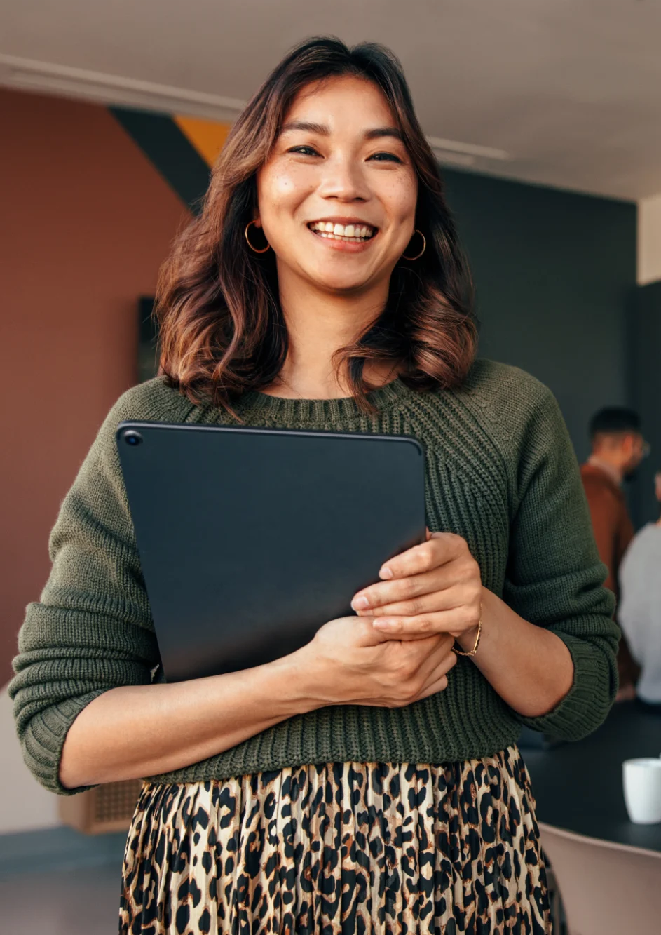 Smiling woman holding a tablet at a professional event or conference.