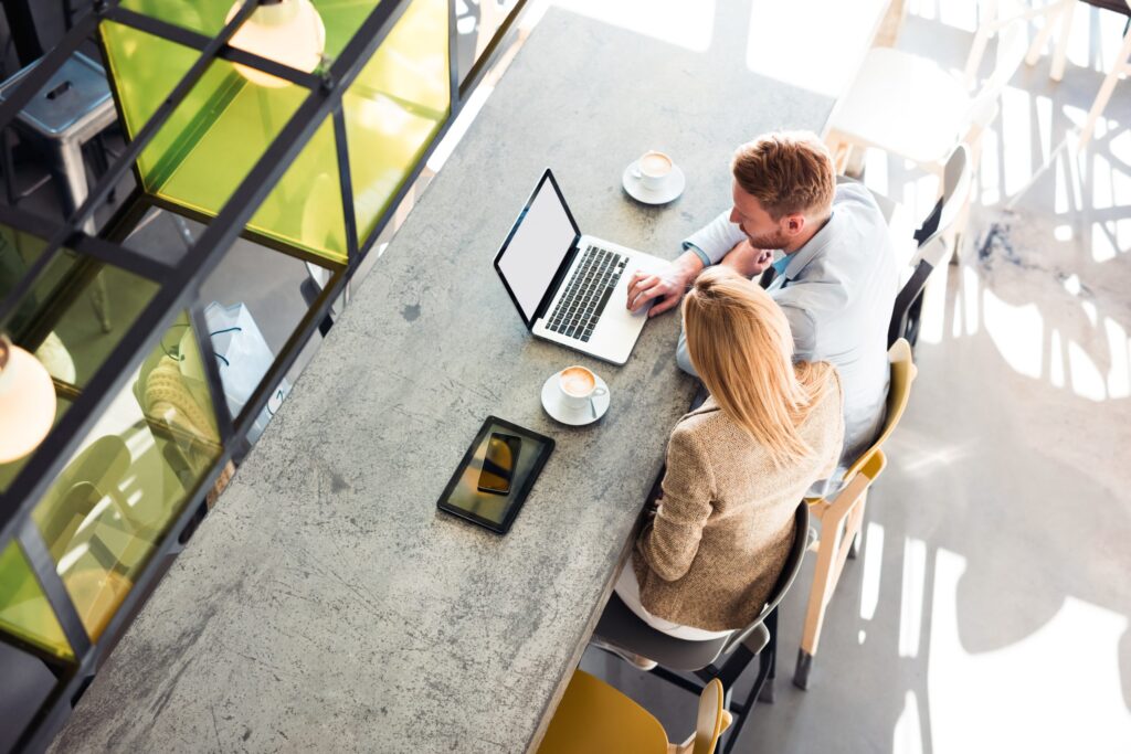 Business colleagues working together at a modern office table with laptops and tablets.