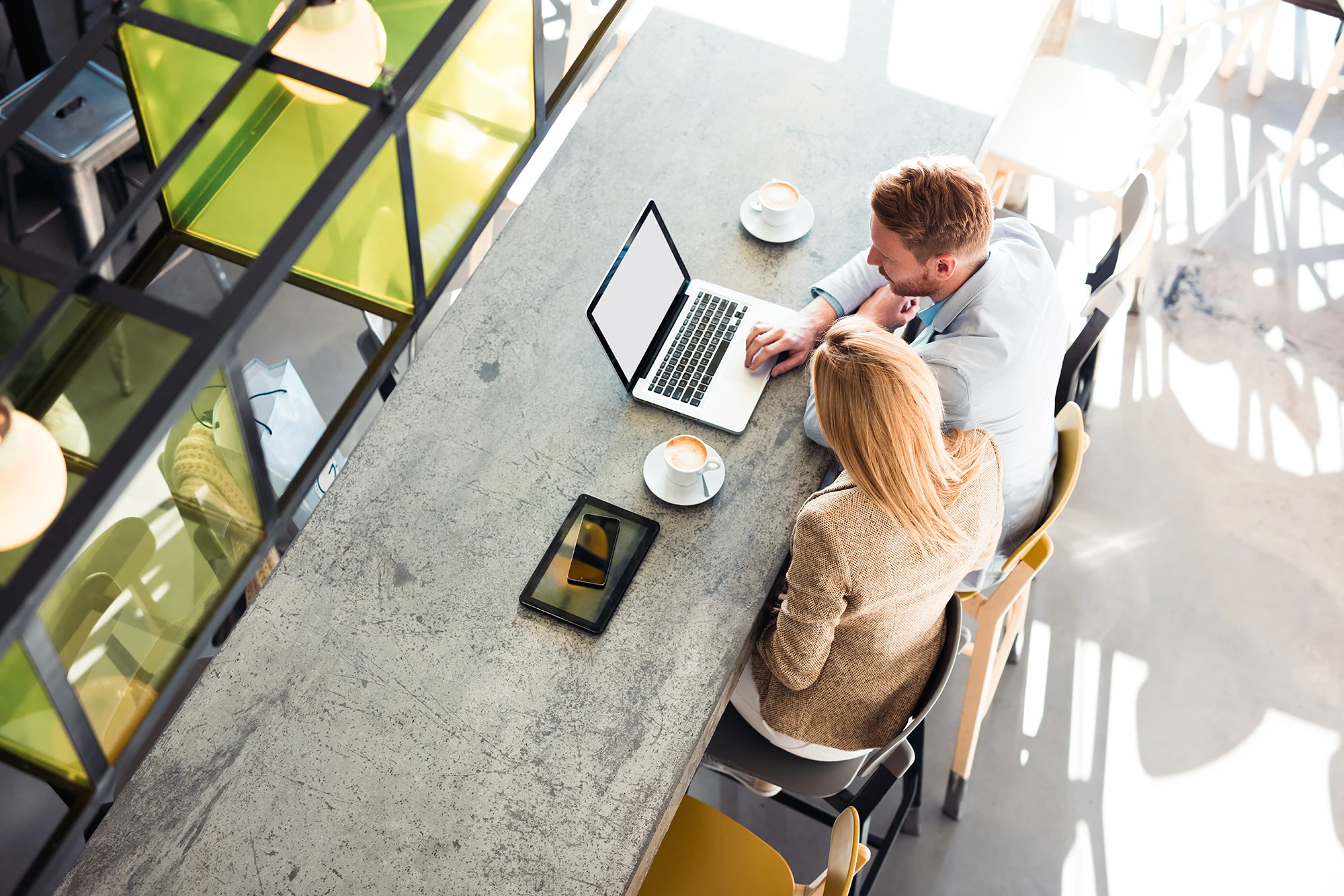 Business colleagues working on laptops at a modern office table during a meeting.